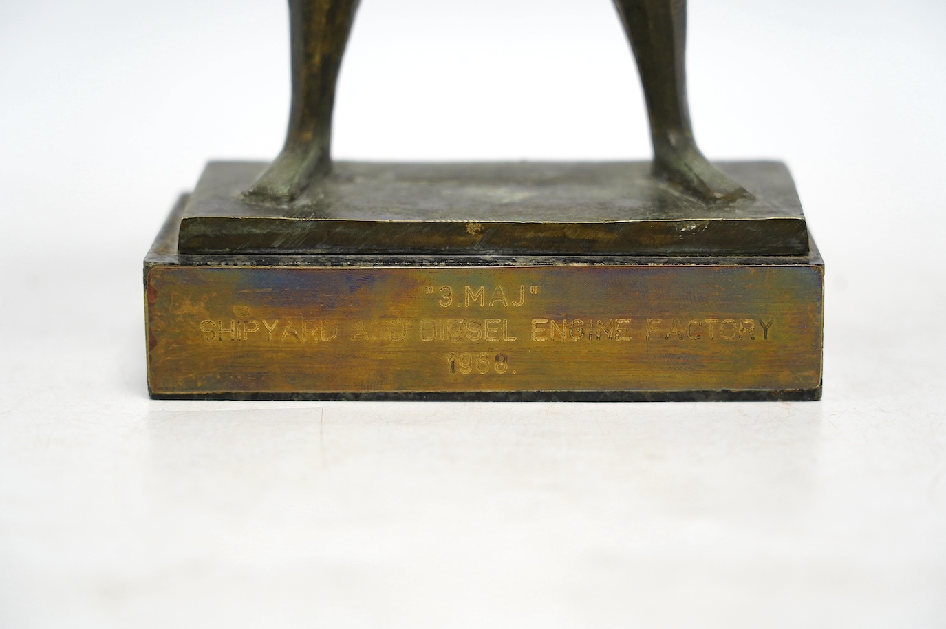 A 1960s modernist bronze figure of a man holding a boat, plaque inscribed ‘“3.MAJ” SHIPYARD AND DIESEL ENGINE FACTORY 1968.’, 29cm. Condition - fair to good